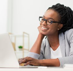 Cheerful Afro Office Girl Using Laptop At Workplace Cheerful Afro Office Girl Using Laptop At Workplace